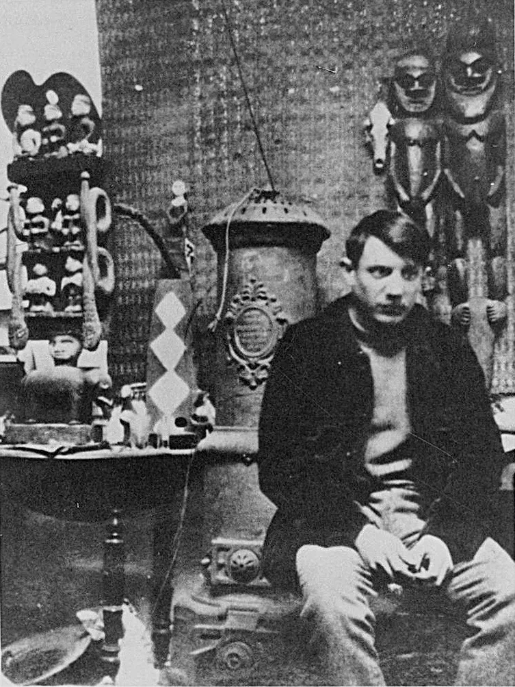 Pablo Picasso en su estudio de Montmartre, París, 1908, rodeado de esculturas africanas. [Fotografía]. Autor desconocido. Dominio público.