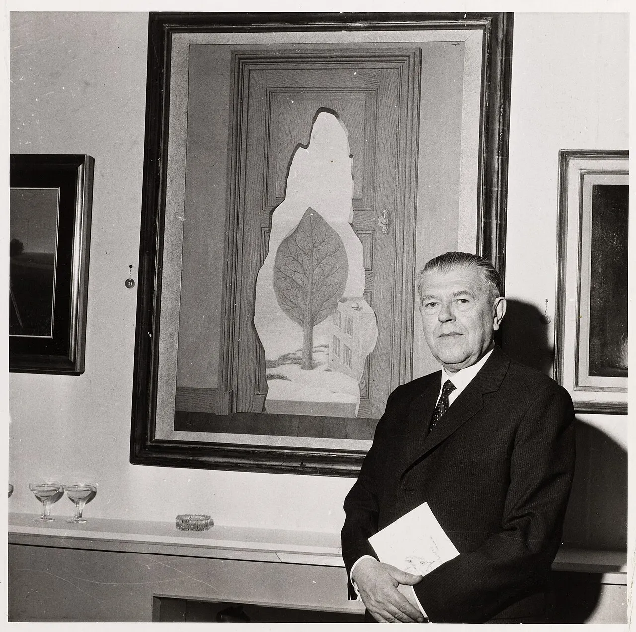 René Magritte (1898–1967) frente a La perspective amoureuse, 1935, París, 18 de octubre de 1961. Fotografía anónima. Musée Carnavalet, Paris Musées. Dominio público (CC0 1.0).